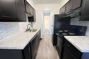 a kitchen with black cabinets and white counter tops and a black stove and refrigerator at Crown Pointe Apartments, Kentucky, 41014